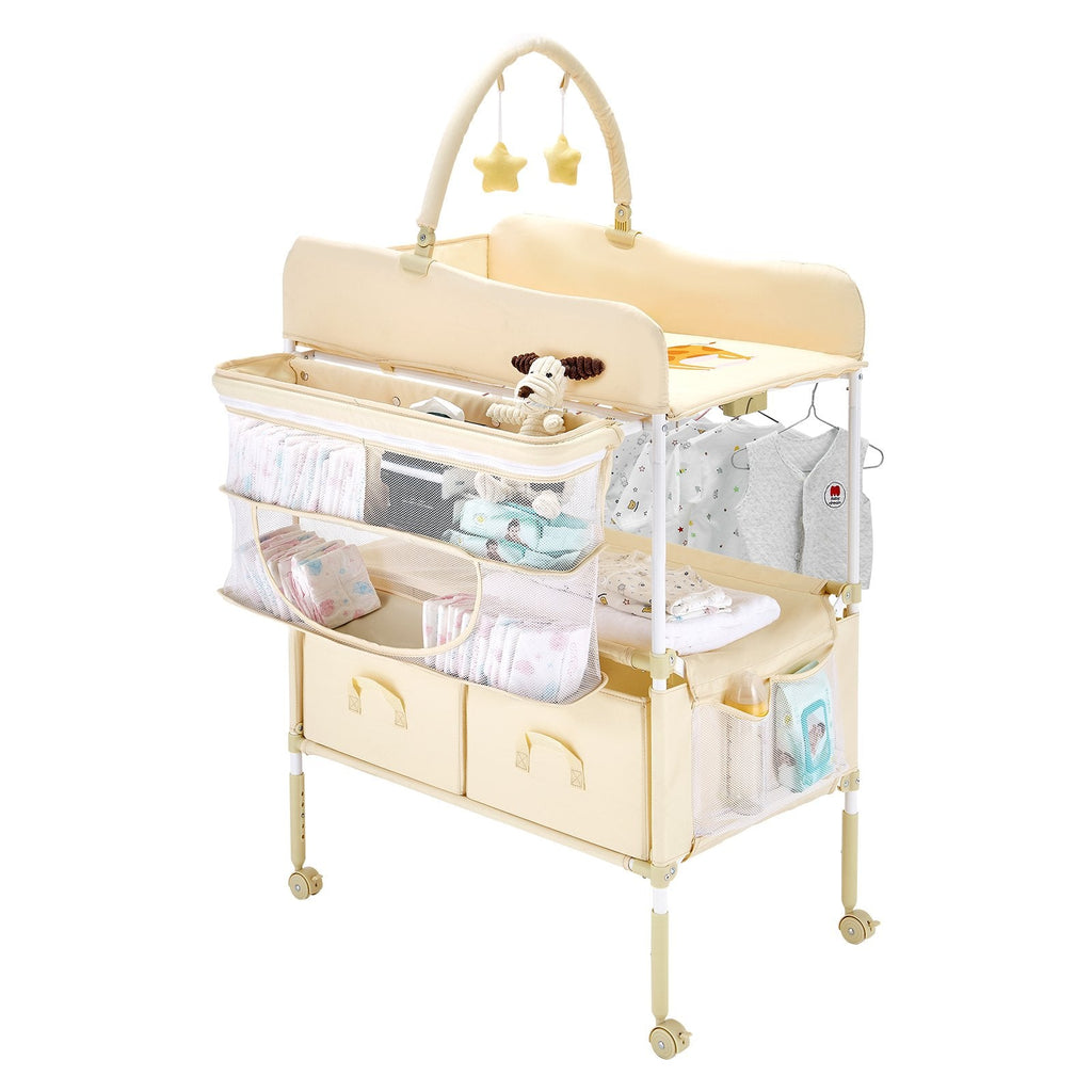 Foldable baby changing table with adjustable height, lockable wheels, fabric drawers, side basket, and hanging rod in light beige.