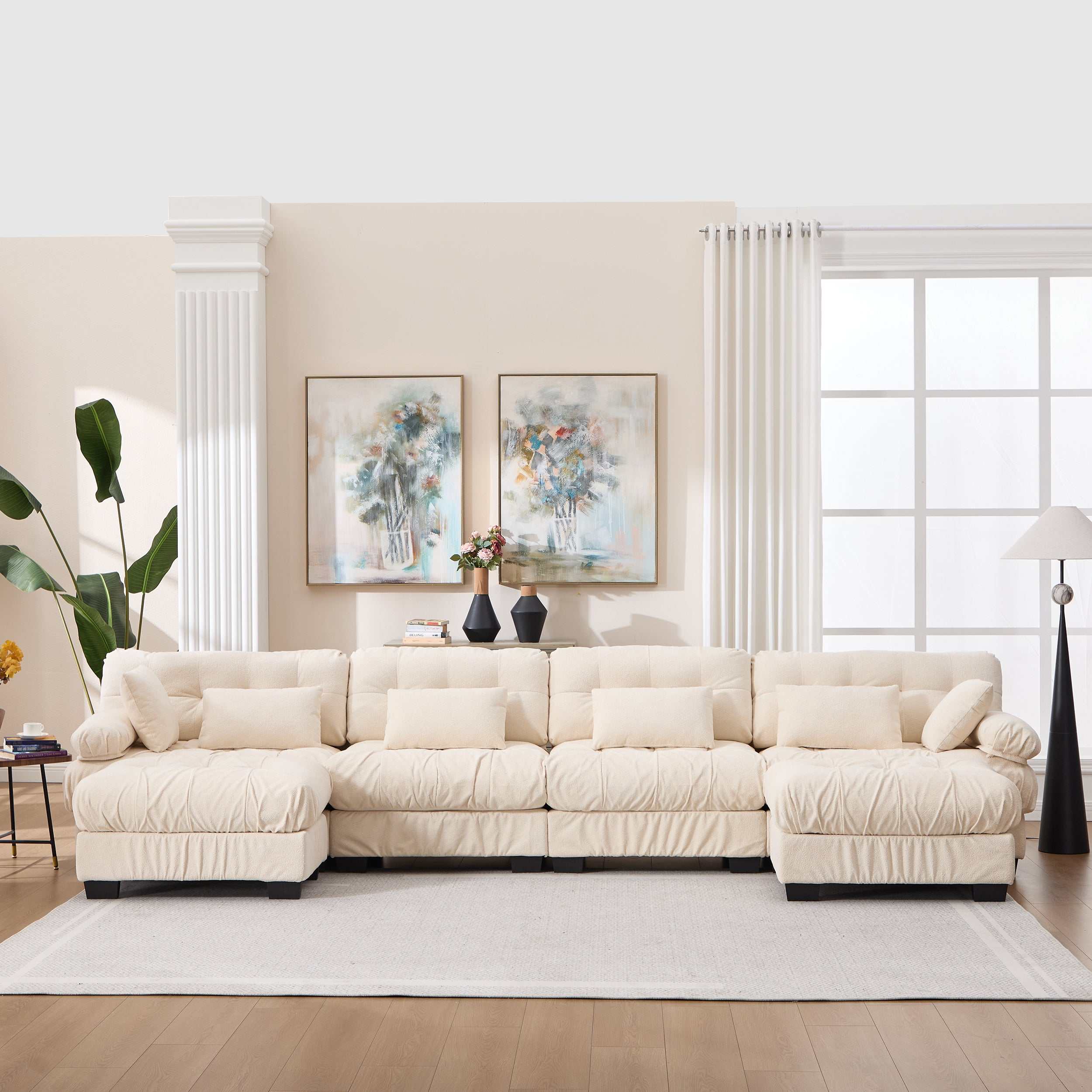 Beige U shaped modular sectional sofa with deep seats, round armrests, and six pillows in a modern living room setting